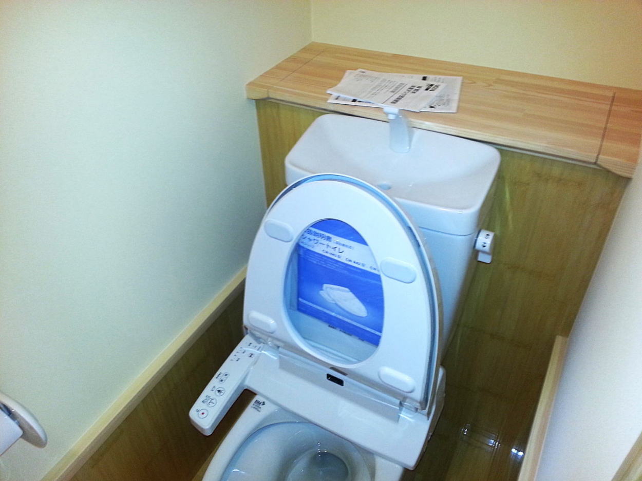 トイレの背面カウンター腰壁に竹のフロアを張りお手入れのしやすさを重視。見せたくないペーパーなどの収納に背面収納を造作