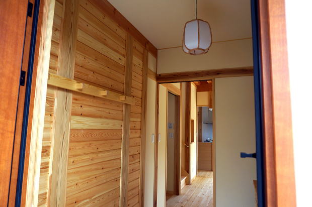 玄関の一部を赤松の羽目板を貼り手作りの天然木のコート掛けを取付